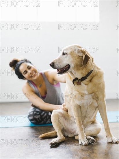 Woman practicing yoga with dog