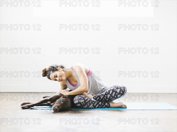 Woman practicing yoga with dog