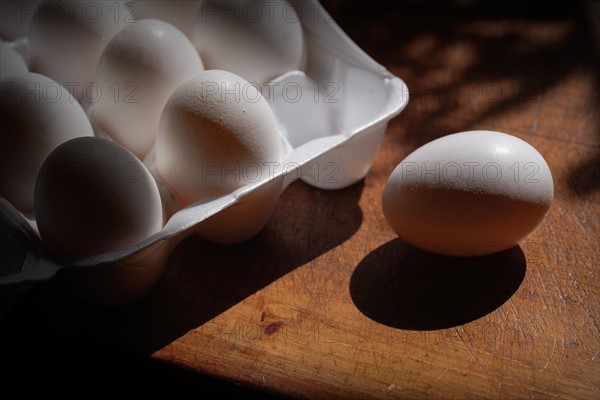 Fresh eggs in carton on table