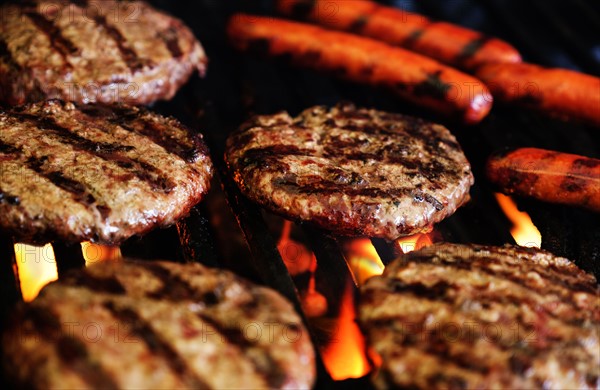 Hamburgers and hot dogs on barbeque grill