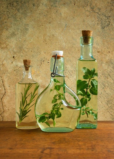 Olive oil bottles with mint, rosemary and oregano leaves