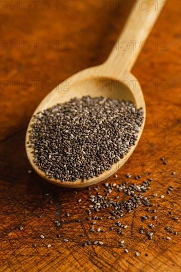 Wooden spoon full of chia seeds on table