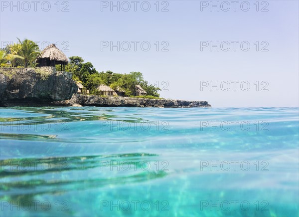 Jamaica, Negril, Traditional huts on rocky coastline