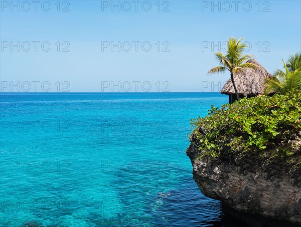 Jamaica, Negril, Traditional huts on rocky coastline