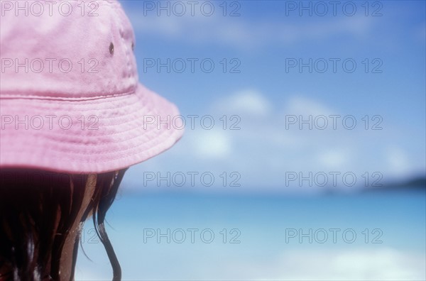 Mature woman in pink sun hat on Caribbean beach