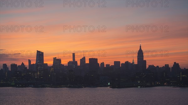 USA, New York State, New York City, Silhouette of city skyline at sunrise