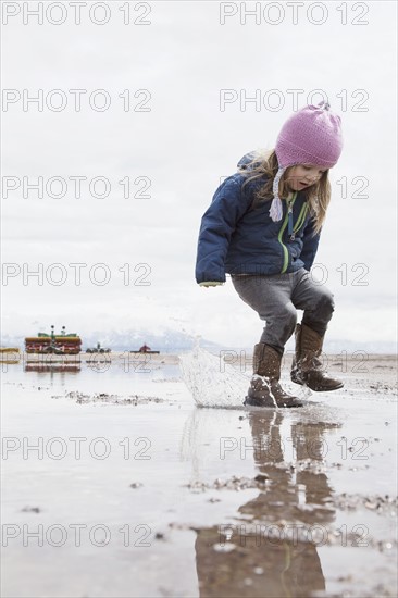 Little girl (4-5) playing in puddle