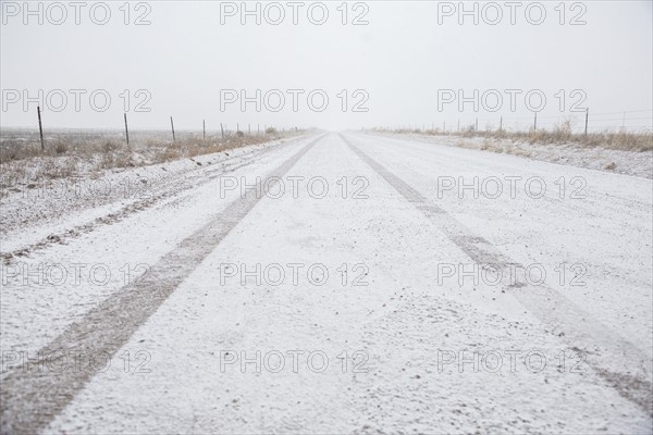 USA, Colorado, Empty dirt road covered with snow