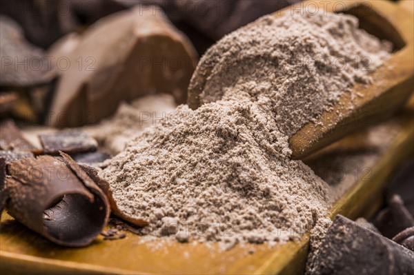 Still life with wooden scoop full with chocolate powder