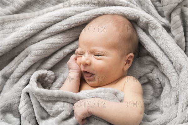 Portrait of little baby boy (0-1 months) wrapped in blanket