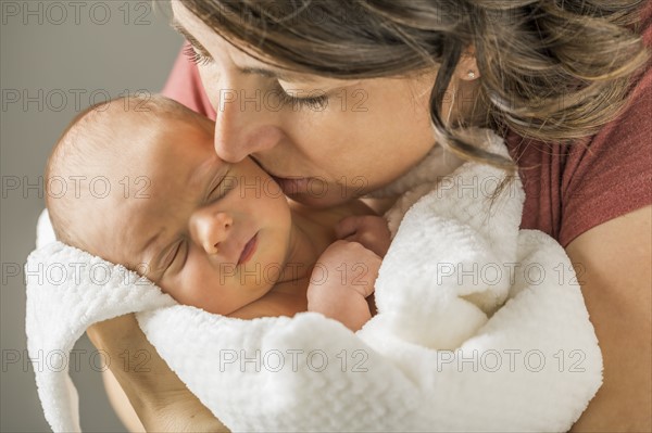 Mother kissing baby boy (0-1 months)