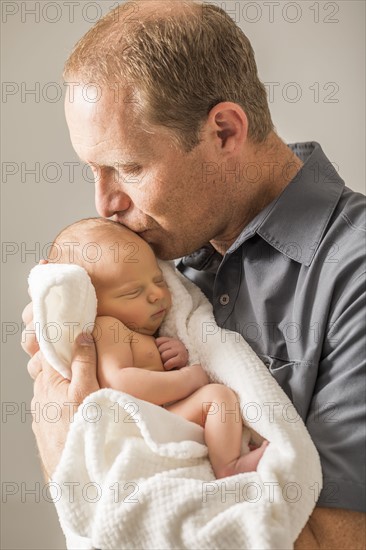 Father embracing newborn son (0-1 month)