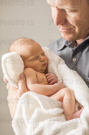 Father embracing newborn son (0-1 month)