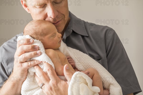 Father embracing newborn son (0-1 month)