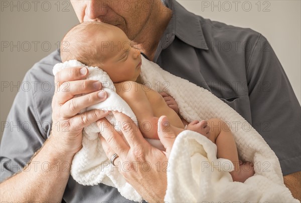 Father embracing newborn son (0-1 month)