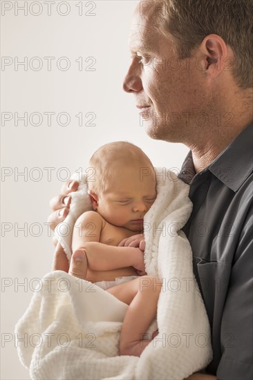 Father embracing newborn son (0-1 month)