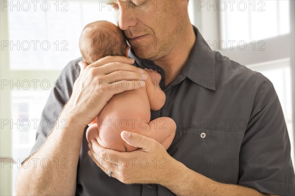 Father embracing newborn son (0-1 month)