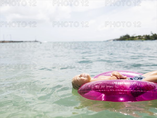 Boy (4-5) swimming on inflatable ring