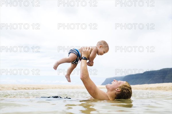 USA, Hawaii, Kauai, Father with baby boy (12-17 months) playing in sea