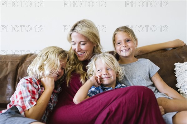 Mother and children (4-5, 6-7, 8-9) resting in living room