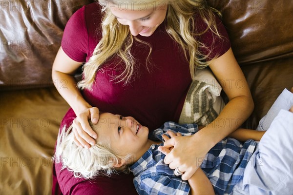 Mother with son (4-5) resting on sofa