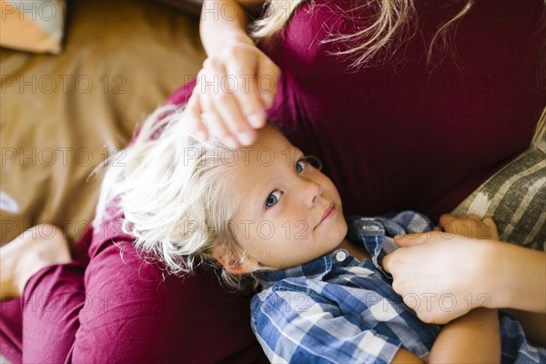 Mother with son (4-5) resting on sofa