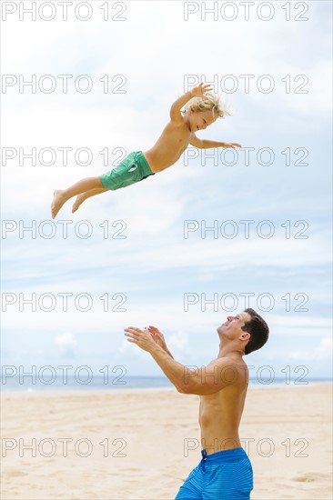 Father with son (4-5) playing at beach