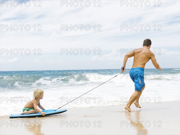 Father with son (4-5) playing at beach