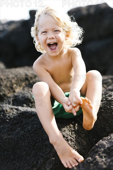 Boy (4-5) playing on rocks