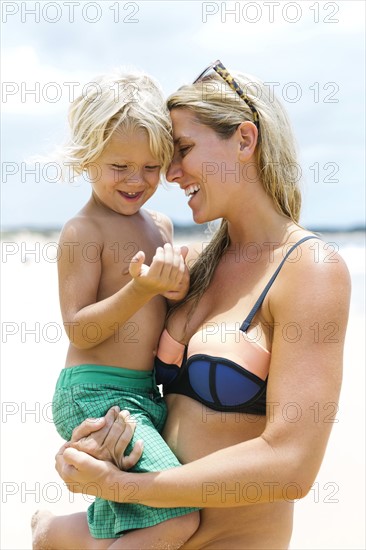 Mother with son (4-5) embracing at beach