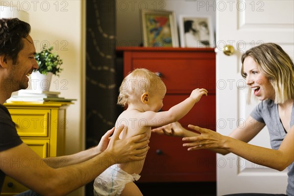 Parents assisting in son's (12-17 months) first step