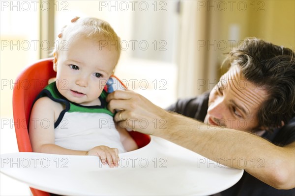 Father measuring son's (12-17 months) temperature