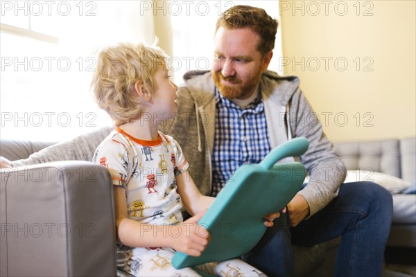 Father and son (4-5) playing with electronic toy