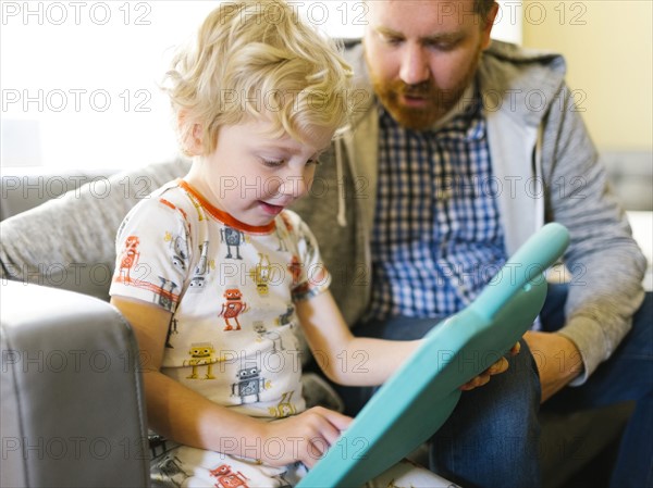 Father and son (4-5) playing with electronic toy