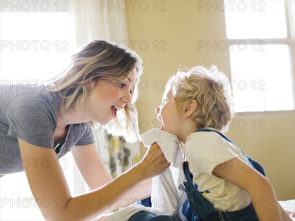 Mother cleaning son's face (4-5) with towel