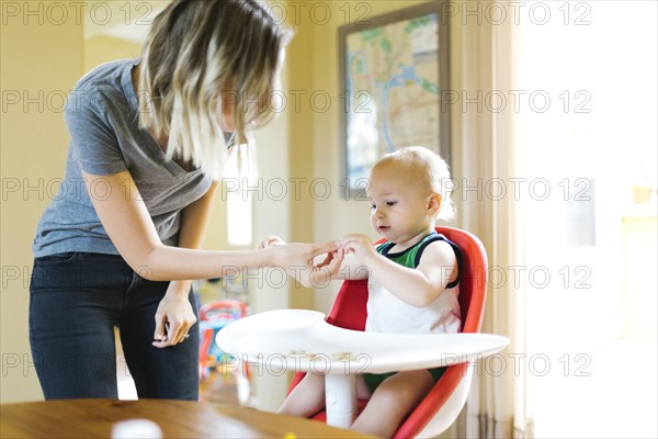 Mother feeding son (12-17 months) with breakfast cereals
