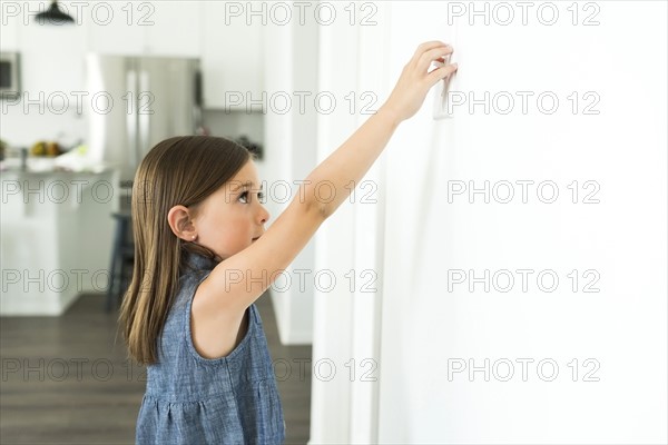 Girl (6-7) turning on lights at home