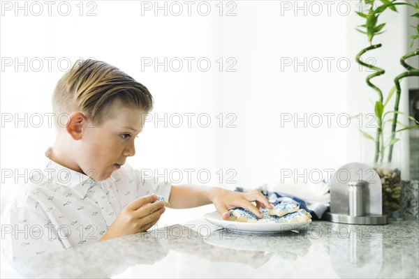 Boy (8-9) eating cookies