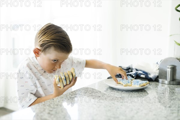 Boy (8-9) stealing cookies