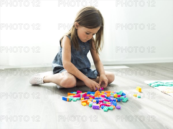 Girl (6-7) playing with plastic blocks