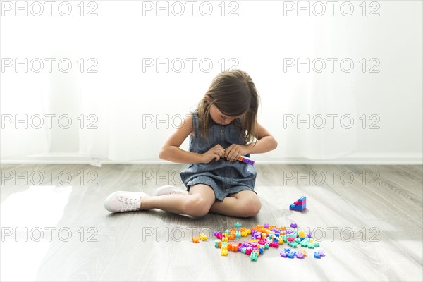 Girl (6-7) playing with plastic blocks