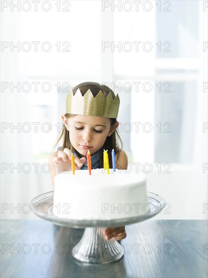 Sad girl (6-7) with birthday cake