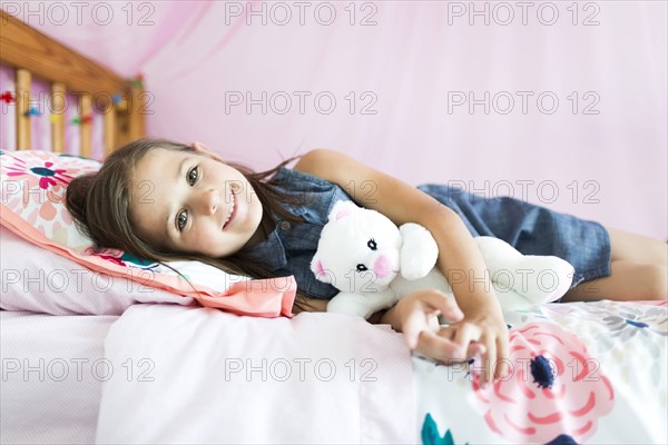 Portrait of girl (6-7) lying on bed