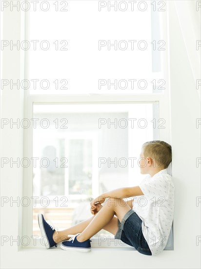 Boy (6-7) looking through window