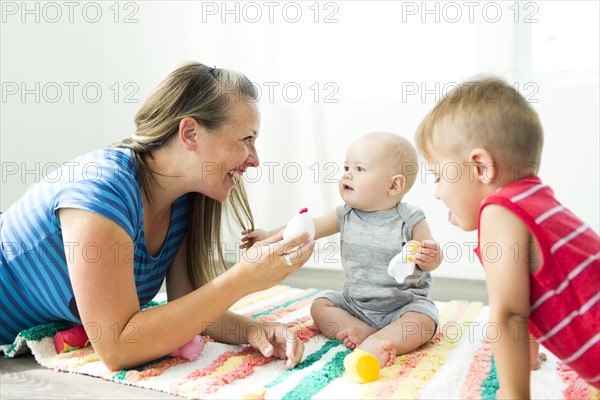 Mother playing with her two children (6-11 months, 2-3)