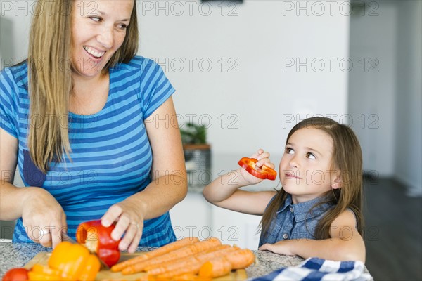 Mother with daughter (6-7) preparing food