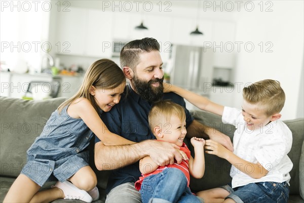 Father playing with his three children (2-3, 6-7)