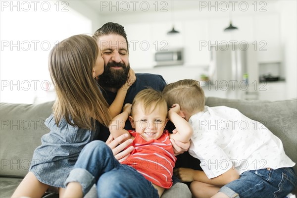 Father playing with his three children (2-3, 6-7)