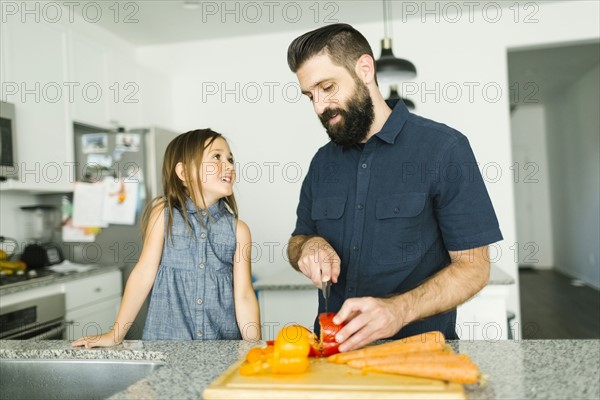 Father with daughter (6-7) cooking together