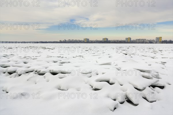 Ukraine, Dnepropetrovsk region, Dnepropetrovsk city, Frozen river with distant cityscape